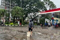Warga membersihkan sisa-sisa banjir di SPBU Ciliwung usai banjir melanda kawasan tersebut. (Agung Budi)